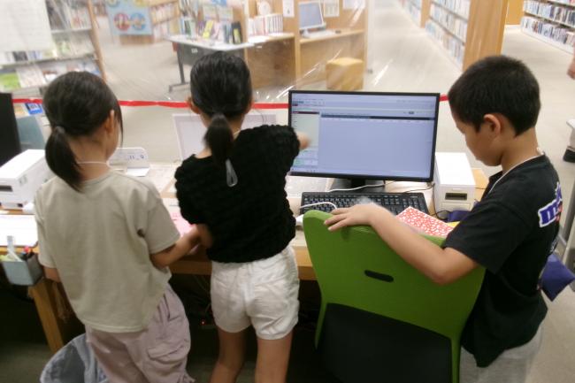 カウンターで本の返却をしている写真