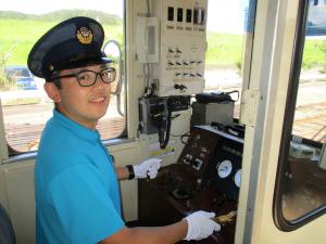 列車の運転席に座っている加洲さんの写真